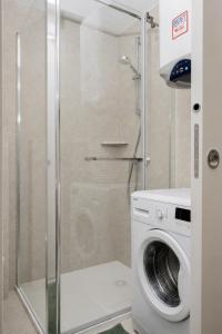 a washing machine in a bathroom with a shower at Sunny Apartment with Terrace in Ankaran