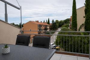 a table and chairs on a balcony with a view at Sunny Apartment with Terrace in Ankaran