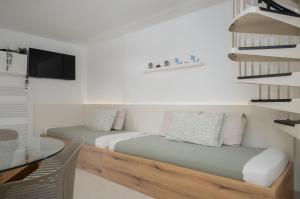 two beds in a room with a table and a tv at Sunny Apartment with Terrace in Ankaran +10 photos