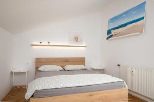 a bedroom with a bed in a white room at Sunny Apartment with Terrace in Ankaran