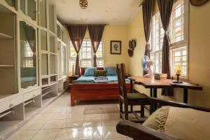 a bedroom with a bed and a desk and windows at Utamaduni House B&B in Arusha