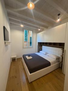 a bedroom with a large bed and a television at Rovetta Tre Piazze Apartments in Brescia