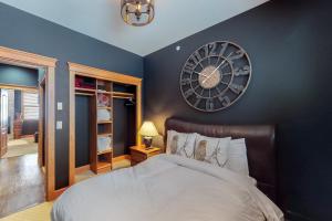 a bedroom with a large clock on the wall at Tree Tops 15 in Big White