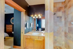a bathroom with a sink and a mirror at Tree Tops 15 in Big White +33 photos