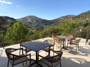 due tavoli e sedie su un patio con le montagne sullo sfondo di Pine Inn a Spilia