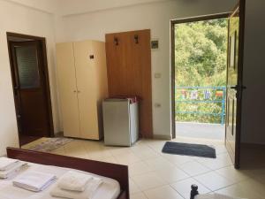 a room with a refrigerator and a sliding glass door at Olive Nest Bunec in Sasaj