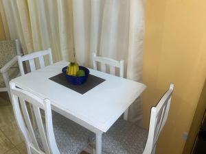 a white table with a bowl of fruit on it at Country Green in La Feuillet +12 photos