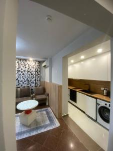 a kitchen and living room with a table and a couch at Luander Hotel in Tirana