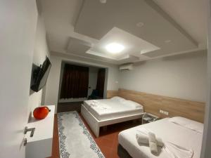 a small room with two beds and a tv at Luander Hotel in Tirana +20 photos