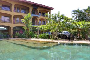 a swimming pool in front of a hotel at Pacifico Loft Hotel in Jacó