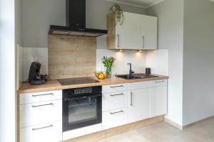 a kitchen with white cabinets and a sink at Ferienwohnung Landblick in Borken +34 photos