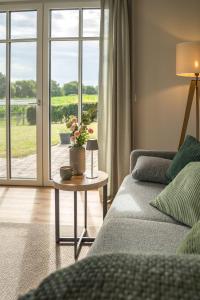 a living room with a couch and a table with flowers on it at Ferienwohnung Landblick in Borken