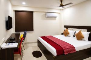 a bedroom with a bed and a desk and a television at Sg Happy Stay in Machilīpatnam