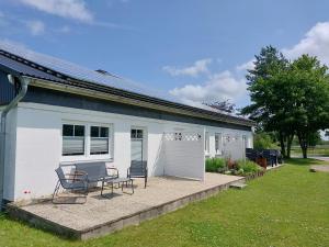 a white house with two chairs and a patio at Sonnenterrasse in Hörup