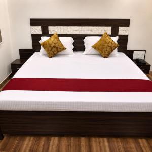 a bedroom with a large bed with white sheets and pillows at Sg Happy Stay in Machilīpatnam +2 photos