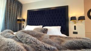 a teddy bear laying on a bed with a blanket at Moulin Royale in Saint-Etienne-Roilaye