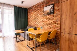 a dining room with a brick wall and a table and chairs at Apartament 24 in Mysłowice +5 photos