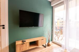 a living room with a tv on a green wall at Apartament 24 in Mysłowice