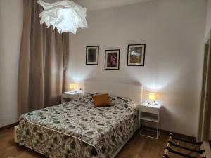 a bedroom with a bed and two tables and a chandelier at Affittacamere Borgo Antico in Venzone