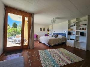 a bedroom with a bed and a sliding glass door at Casa Conte in Orselina