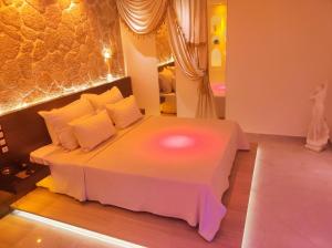 a bedroom with a bed with a pink light on it at GLS Priamos in Piraeus