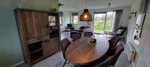 a living room with a wooden table and chairs at Mooi Drenthe in Wezuperbrug