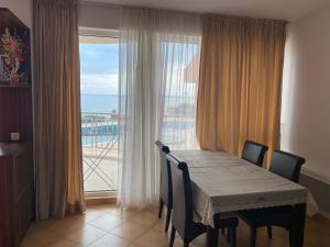 a dining room table with chairs and a view of the ocean at Bellevue Beachfront Paradise in Ravda