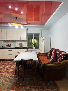 a living room with a table and a couch at Azamat in Kara-Koo