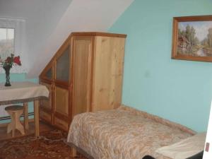 a bedroom with a bed and a wooden cabinet and a table at Agroturystyka u Jasienka in Mrukowa