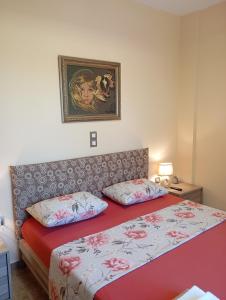 a bedroom with a bed with red sheets and a picture on the wall at "Villa Kastania" Melidoni, Chania, Crete in Melidhónion +49 photos