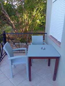a white table and two chairs on a balcony at Amentas Luxury Apartments in Vrontádos +11 photos