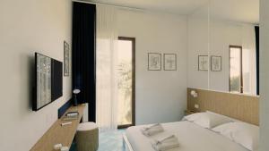 ein weißes Schlafzimmer mit einem Bett und einem Fenster in der Unterkunft Hotel Cerere in Paestum