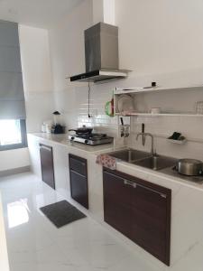 eine weiße Küche mit Spüle und Herd in der Unterkunft TamApartment in Ko Phangan