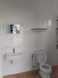ein Badezimmer mit Waschbecken, Toilette und Spiegel in der Unterkunft TamApartment in Ko Phangan