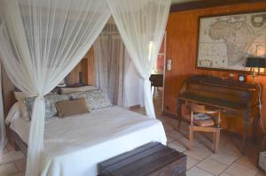 a bedroom with a bed and a grand piano at Harmonie in Rivière Noire +29 photos