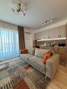 a living room with a couch and a kitchen at Oasis-First Estates Pipera in Voluntari