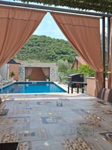 a pool with a view of a house with a piano at Vila Olive 51 in Tivat +14 photos