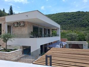 a house with a hill in the background at Vila Olive 51 in Tivat