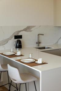 a kitchen with two chairs and a counter with plates and cups at The Downtown Largo do Carmo in Faro +74 photos
