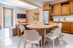 a kitchen with a wooden table and white chairs at Spacious 4BR Home with Lake View in Nesso