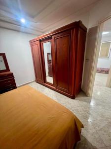 a bedroom with a bed and a wooden cabinet at Dar Meriem in Korba