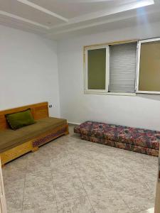 two beds in a room with two windows at Dar Meriem in Korba