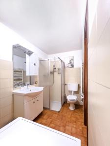 a bathroom with a toilet and a sink and a shower at Spacious 4BR Home with Lake View in Nesso +34 photos