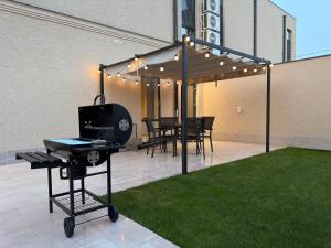 a patio with a grill and a table and chairs at Luxe House Odessa Private Jacuzzi BBQ, Free Parking in Odesa