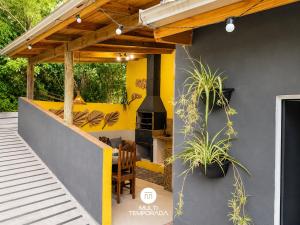a patio with a fireplace in a house at Pousada Coração do Rosa - Praia do Rosa/SC in Praia do Rosa