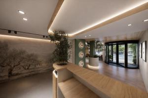 a lobby with a bench and a wall with paintings at Hospedium GL Hotel Andújar in Andújar