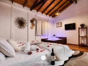 a bedroom with a large bed with roses on it at Pousada Coração do Rosa - Praia do Rosa/SC in Praia do Rosa