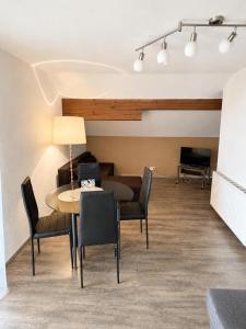 a living room with a table and chairs and a couch at Ferienwohnung Bergpanorama Waldweg in Altmünster +7 photos