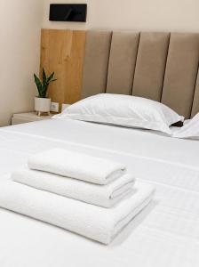 a pile of towels sitting on a bed at Tirana Lake Bliss Apartment in Sauk