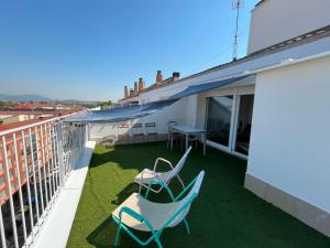 a patio with two chairs and a table on a balcony at Atico en el centro de Vitoria Parking gratis in Vitoria-Gasteiz
